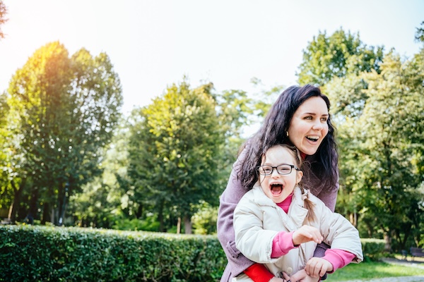 Woman and child enjoy walk autumn sunny day outside. Happy family moments concept. Lovely child in eyeglasses with cute facial expression.