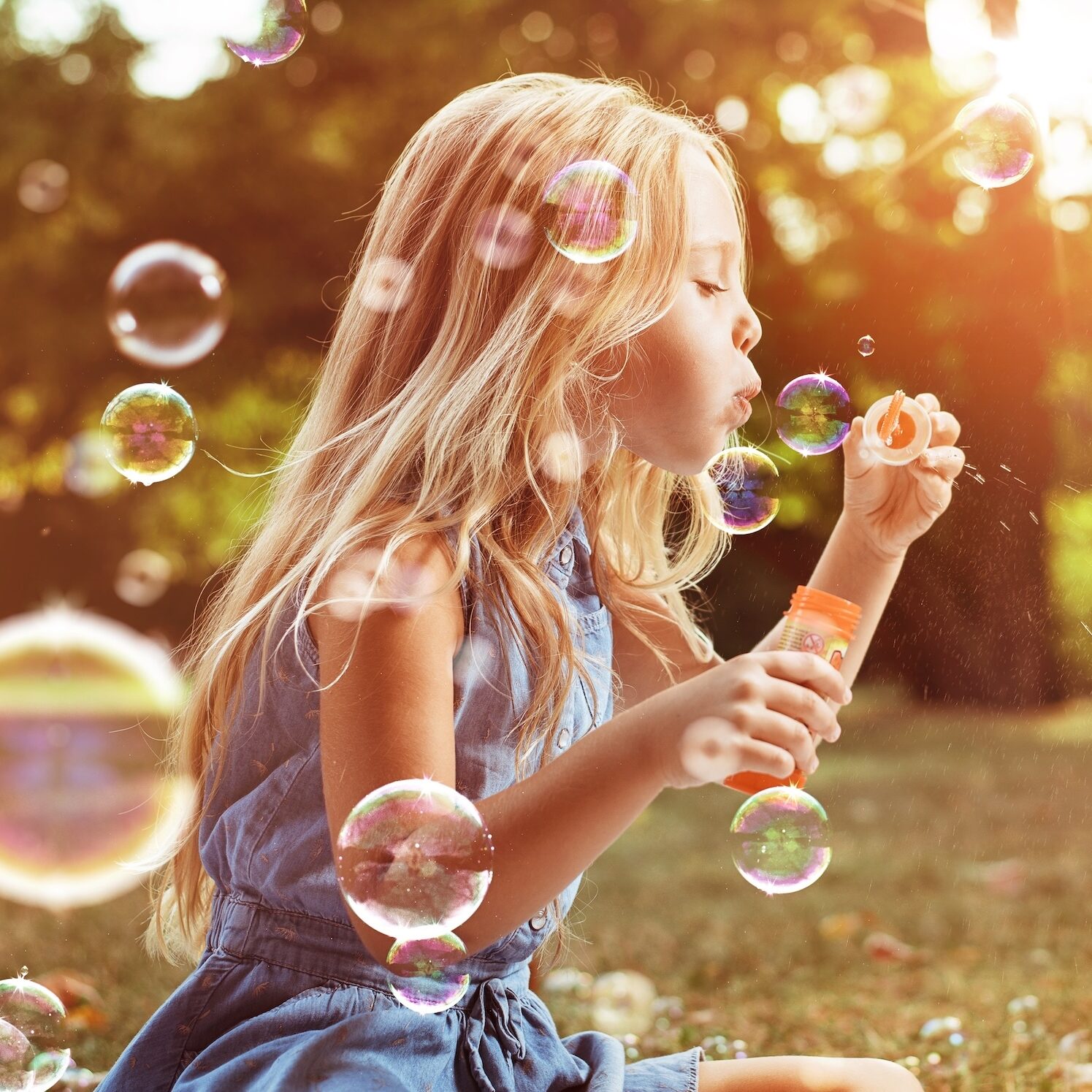 Portrait of a cheerful child blowing soap bubbles